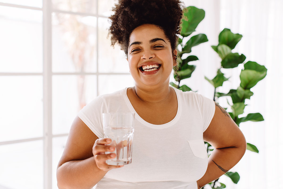 A woman drinking water happy with her ROSE procedure in Plano.